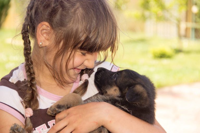 Kind houdt een jonge hond vast