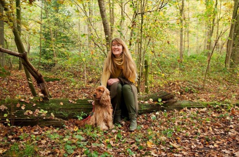 Vrouw zit met haar hond in het bos