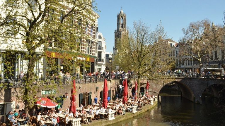 Gracht met terrassen en een kerktoren